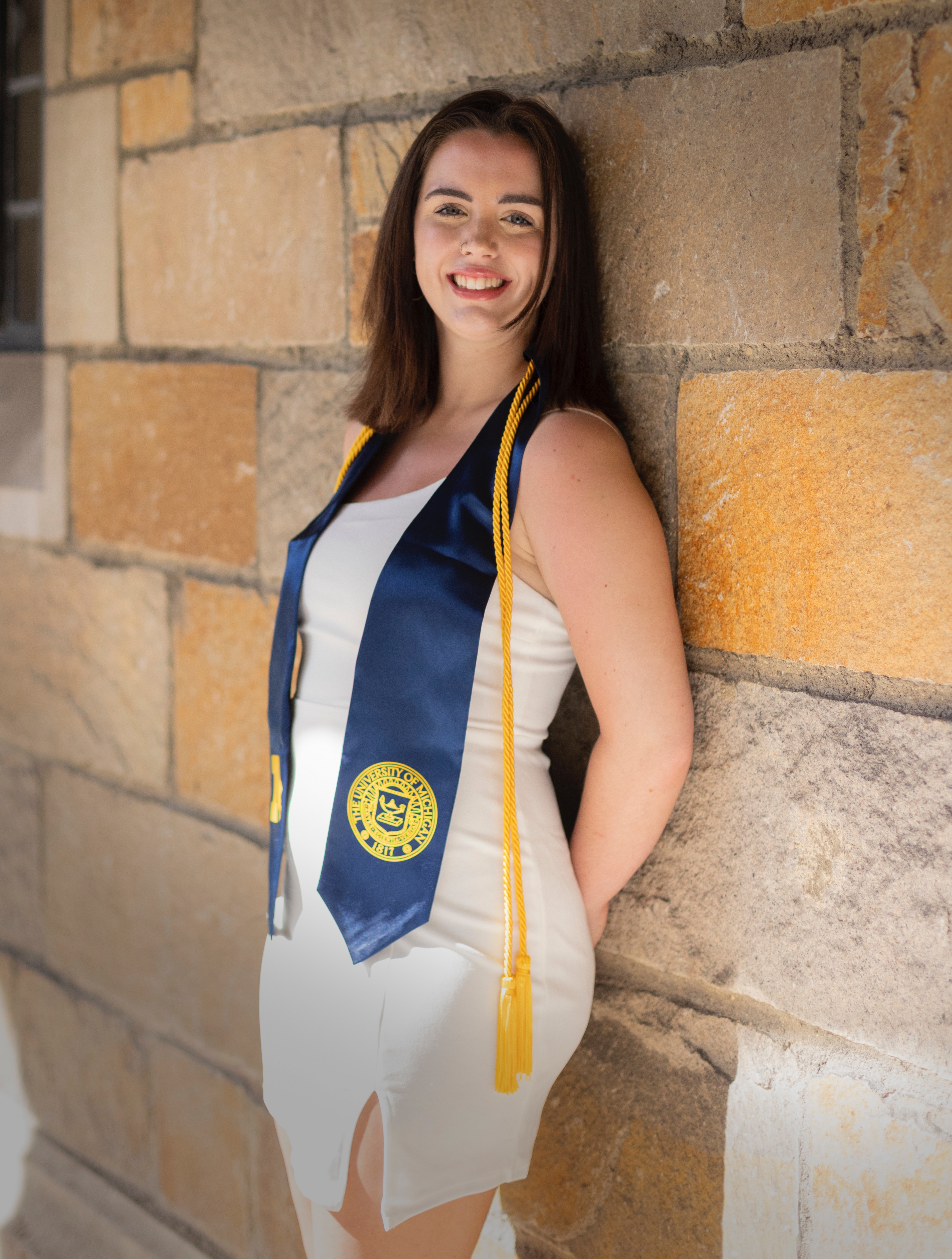 University of Michigan graduate portrait against stone architecture - premium senior photography example